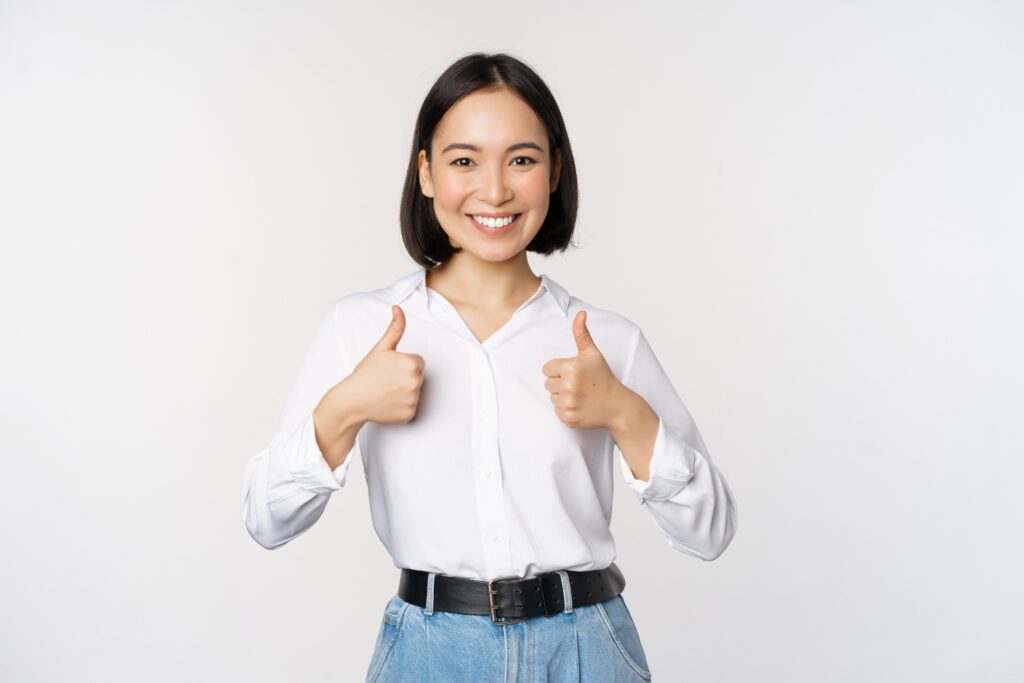 asian woman showing thumbs up